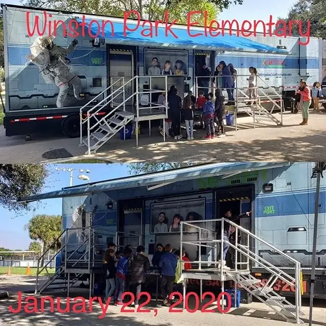 The Intergalactic Adventures trailer parked at a school, with students lining up at the entry stairs